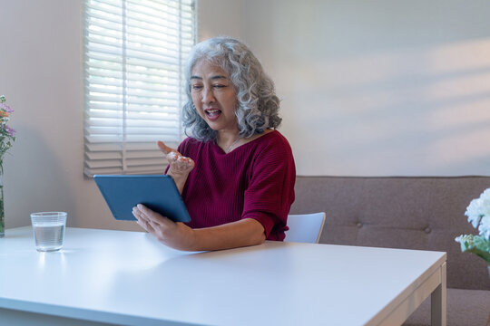 Elderly Woman Using Tablet for Video Call