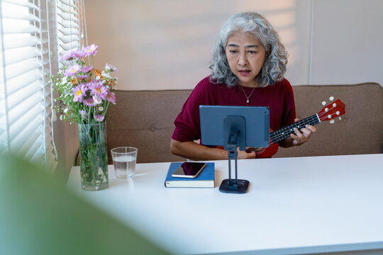 Senior Woman Using Tablet For learning Instrument - Powered by Adobe