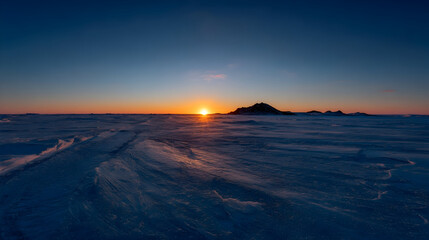 Majestic sunrise over snow-covered mountains highlighting the beauty of winter wilderness at dawn