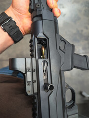 A close-up, detailed view of a firearm malfunction, with a live ammunition 9mm round jammed in the...