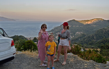 A family (a mother, her adult daughter, and her grandson) pose during a morning hike through the...