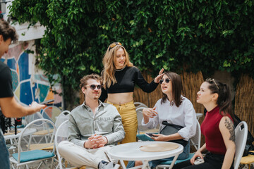 Five young individuals socializing in a friendly environment, showcasing a lively outdoor cafe...