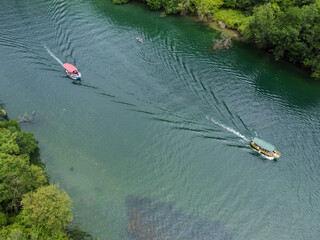 Deep river canyon between mountains, drone footage. A tourist boat sails on the river. Matka...