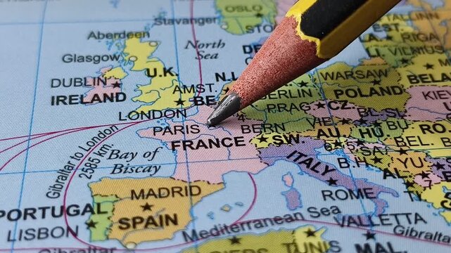 Closeup of pencil tip touching france county location or territory on a public map with some french city name word or text written on the surface. Travel tourism creative concept.