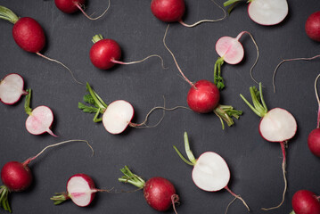 Scattered Fresh Radishes And Slices Artistically Arranged On Dark Surface