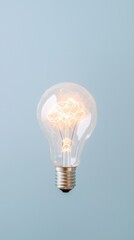 Electric current glowing through tungsten filament, symbolizing innovative thinking against minimalist blue background