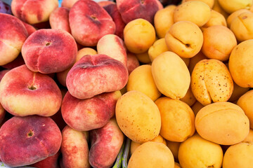 A colorful display of fresh peaches and juicy apricots at a local farmers market, showcasing seasonal fruits