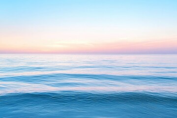 Obraz premium Calm, pastel-toned sunrise over a tranquil ocean. Soft colors blend seamlessly from pale blue to rosy-pink in the sky, reflecting in the smooth, rippled water