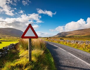sign yield by a small narrow country road with stunning nature scenery in the background warm sunny day picturesque view on vast field and blue cloudy sky connemara ireland