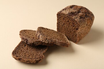 Pieces of fresh rye bread on beige background, closeup