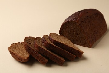 Pieces of fresh rye bread on beige background, closeup