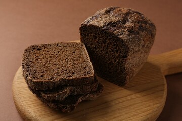 Pieces of fresh rye bread on brown background, closeup