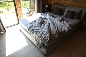 Comfortable bed near window in hotel room