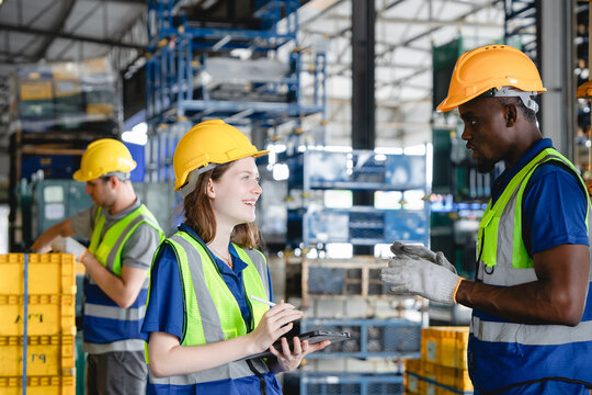 Warehouse logistics team discussing parts management during operations, showing cooperation and multicultural teamwork in smart automotive transport environment. - Powered by Adobe