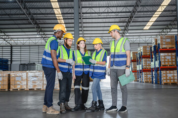 Multiracial warehouse team discussing inventory and logistics strategy during morning briefing with digital tablets and checklists.