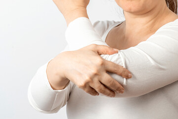 Arthritis symptoms, suffering from pain. The hands of the woman massage a painful elbow. Inflamed male joint, stiffness of movement. Close up view
