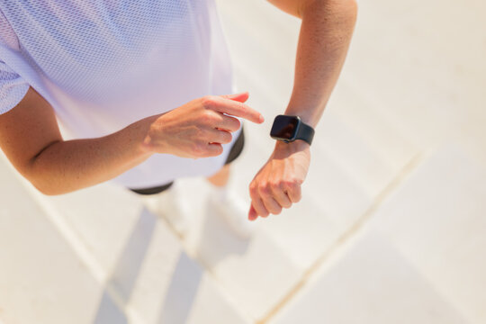 Fitness enthusiast checking smartwatch during a morning jog session