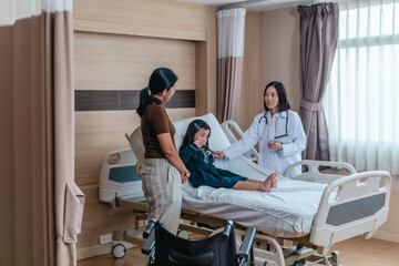 Caring Asian Female Doctor with Child Patient and Mother