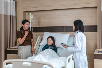 Caring Asian Female Doctor with Child Patient and Mother