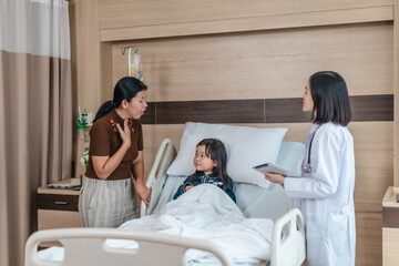Caring Asian Female Doctor with Child Patient and Mother
