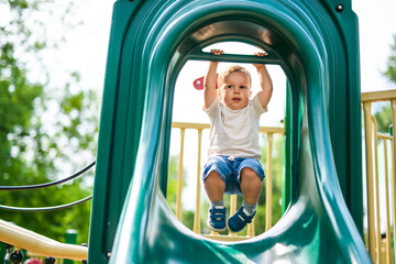 baby playing on outdoor playground. Kids play on school or kindergarten yard.