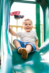 baby playing on outdoor playground. Kids play on school or kindergarten yard.