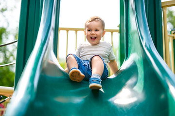 baby playing on outdoor playground. Kids play on school or kindergarten yard.
