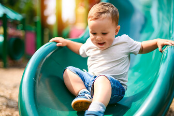 baby playing on outdoor playground. Kids play on school or kindergarten yard.
