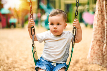 Child girl playing on outdoor playground. Kid play on school or kindergarten yard