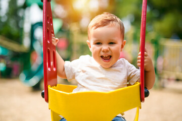 Child girl playing on outdoor playground. Kid play on school or kindergarten yard