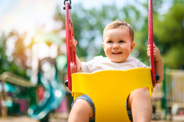 Child girl playing on outdoor playground. Kid play on school or kindergarten yard
