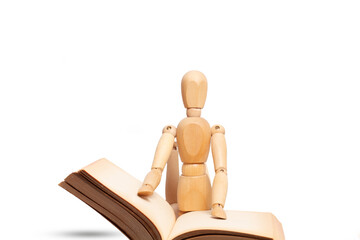 A wooden mannequin reading a book isolated on a white background
