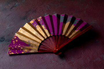 Elegant red and navy fan adorned with floral patterns displayed on a vibrant purple background showcasing traditional craftsmanship