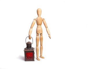 A wooden toy mannequin holding a candle lamp in his hand on white background