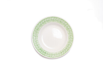 A green and white ceramic round plate on a white background in a top view