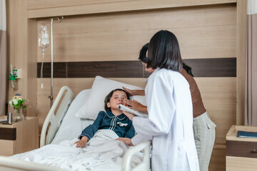 Caring Asian Female Doctor with Child Patient and Mother