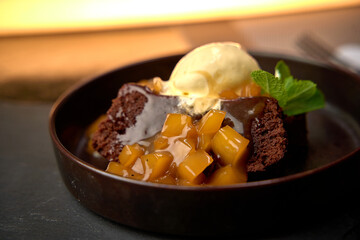 Decadent Chocolate Cake with Caramelized Fruit and Vanilla Ice Cream Served on Elegant Plate for Dessert Indulgence