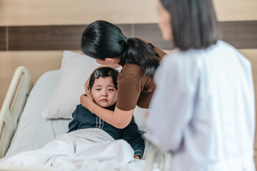 Caring Asian Female Doctor with Child Patient and Mother