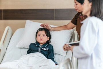 Caring Asian Female Doctor with Child Patient and Mother