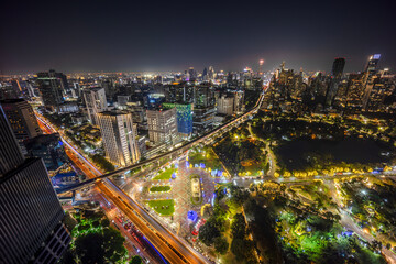 Obraz premium Cityscape building modern business district of Bangkok. X-shaped expressway, sky train railway in the foreground at night time.