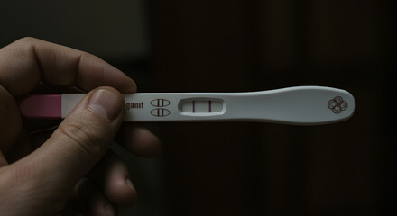 Positive pregnancy test result held in hand conveys anticipation and hope