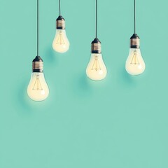Four incandescent light bulbs hang from black wires against a mint green backdrop.  Warm light illuminates the bulbs