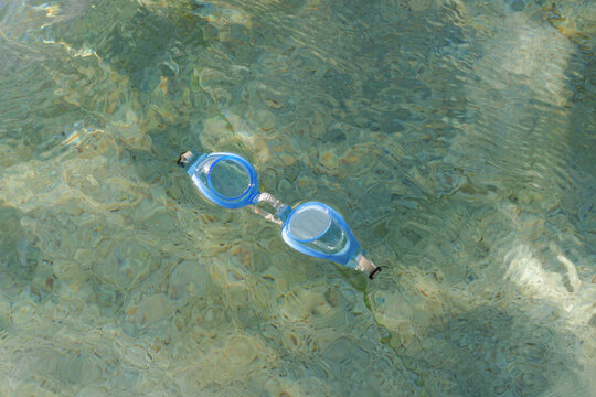 Swimming goggles are floating in the swimming pool. Swimming pool with clear water 
