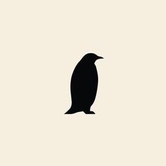 Obraz premium A simple black silhouette of a penguin standing against a light cream-colored background.
