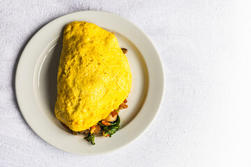 Omelet, desayuno americano tradicional servido sobre una mesa blanca 