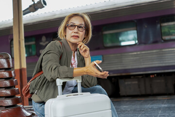 Happy Asian senior boarding a train at the station
