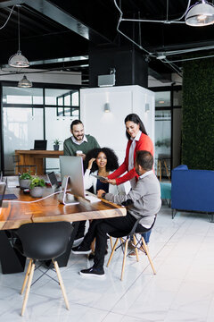 latin business people having a discussion and working in an office in Mexico Latin America, hispanic coworkers using laptop or tablet