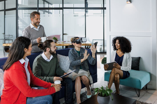 Group of young latin business people using virtual reality glasses during meeting testing VR headset at office in Mexico Latin America. hispanic people at working at job