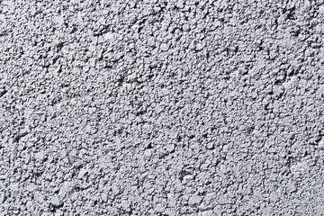 Rough textured wall surface. Gray stucco plaster with visible structure. Macro closeup of building material. Abstract pattern background. Exterior insulation with sprayed facade finish.
