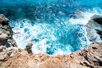 Obraz premium Aerial view on turquoise sea waves crashing against the rocks, Ayia Napa, Cyprus. 
